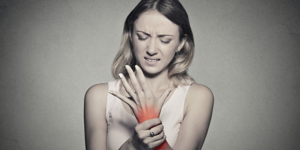 woman holding her painful wrist